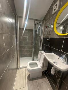 A modern bathroom featuring a tiled shower encl...