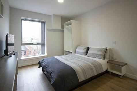 This cozy double bedroom features large windows...