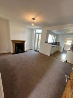 Spacious living room featuring large windows th...