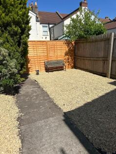 A charming garden area featuring a gravel surfa...