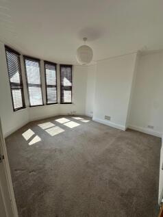 A bright and spacious living room featuring lar...
