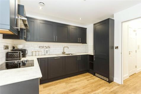 This modern kitchen features sleek cabinetry, a...