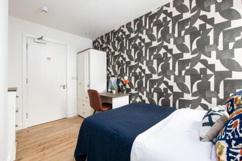 A stylish double bedroom featuring a cozy bed w...