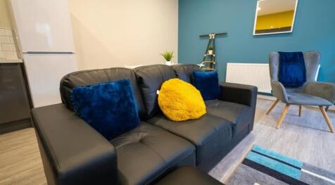 A cozy living room featuring a stylish black le...