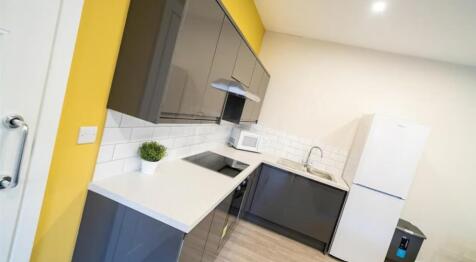 A modern kitchen featuring sleek grey cabinets,...