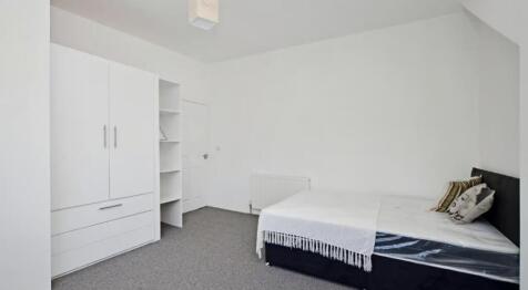 Spacious double bedroom featuring a cozy setup,...