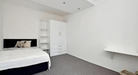 This inviting double bedroom features a cozy at...