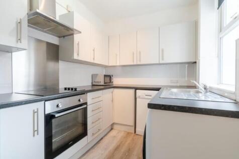 This modern kitchen features sleek cabinetry, a...