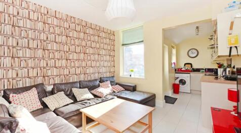 This vibrant living room features a cozy leathe...