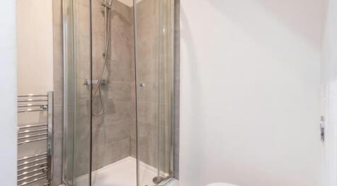 This modern bathroom features a sleek glass sho...