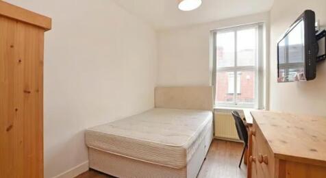 This cozy double bedroom features ample natural...