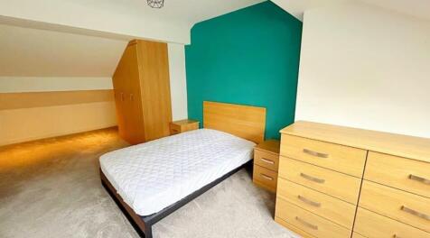 This cozy double bedroom features a stylish woo...