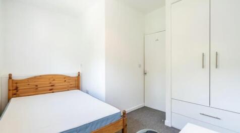 This cozy double bedroom features ample natural...
