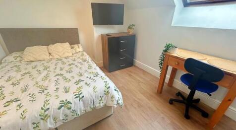 This inviting double bedroom features a comfort...