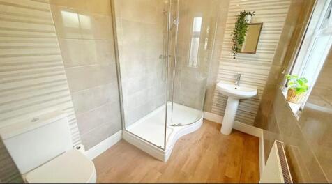 This stylish bathroom features a spacious walk-...
