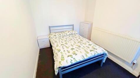 This cozy double bedroom features a comfortable...