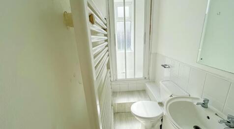 This bright and modern bathroom features a clea...