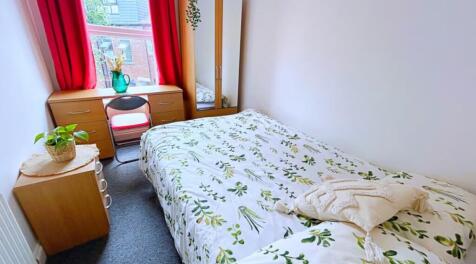 A cozy double bedroom featuring a beautifully p...
