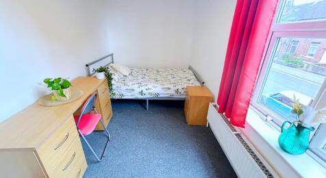 This cozy double bedroom features ample natural...