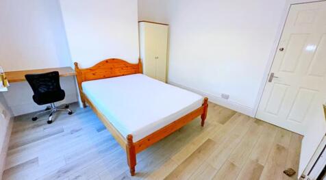 This spacious double bedroom features a cozy wo...