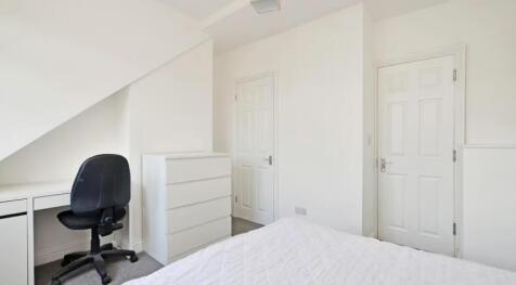 This inviting double bedroom features a cozy at...