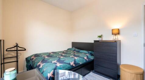 This cozy double bedroom features a comfortable...
