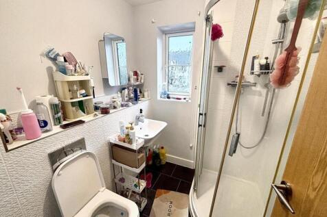 This well-lit bathroom features a modern shower...