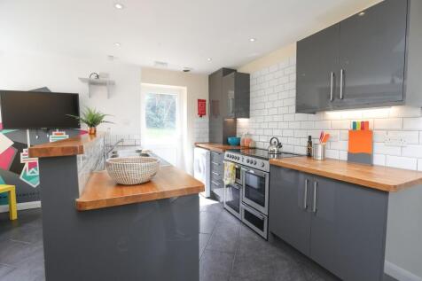 A modern kitchen featuring sleek grey cabinets ...