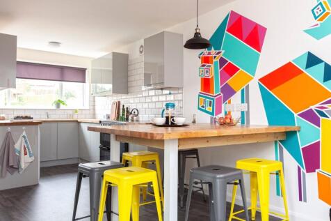 A modern kitchen featuring vibrant wall art and...