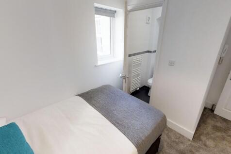 This cozy double bedroom features a comfortable...