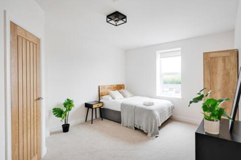 A bright and tidy double bedroom featuring a co...