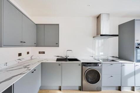 A modern and clean kitchen with grey cabinets a...