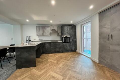 A modern kitchen featuring sleek cabinetry and ...