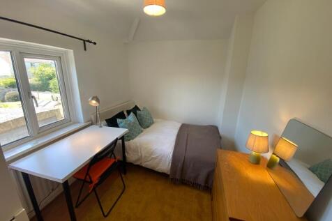 This inviting double bedroom features a cozy at...