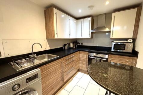 A modern and clean kitchenette with stylish cab...