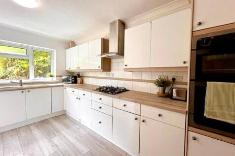 A bright and modern kitchen featuring ample sto...