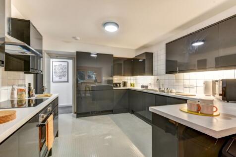 Modern kitchen featuring sleek cabinetry, ample...