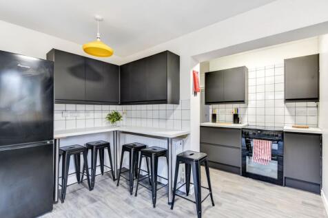Modern kitchen featuring sleek black cabinetry ...