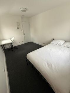 This inviting double bedroom features a cozy at...