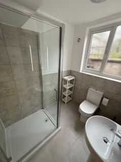 A modern bathroom featuring a spacious shower, ...