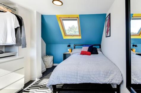 This cozy double bedroom features vibrant wall ...