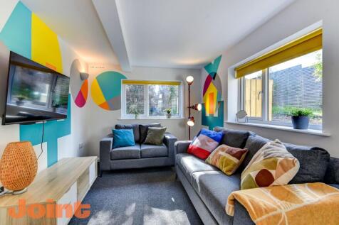 This vibrant living room features a cozy seatin...