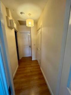 A well-maintained hallway featuring a warm ligh...