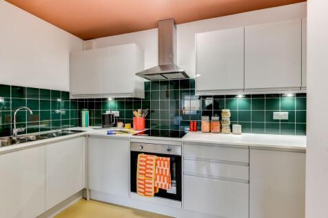 This modern kitchen features sleek cabinetry, a...