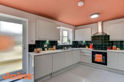Modern kitchen featuring sleek white cabinetry ...