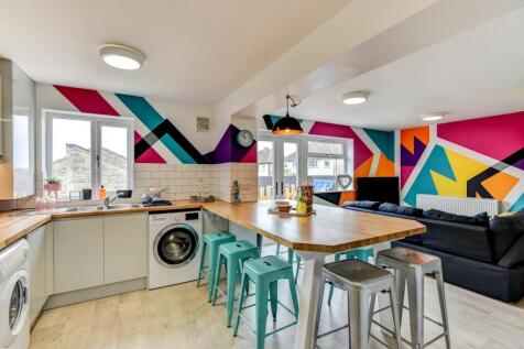 This vibrant and modern kitchen boasts a spacio...