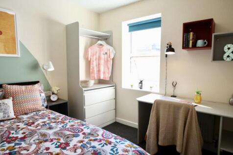 This cozy double bedroom features a vibrant dec...
