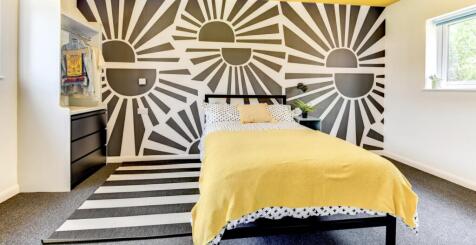 This vibrant double bedroom features a stylish ...