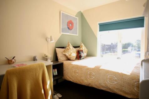 This charming double bedroom features a cozy be...
