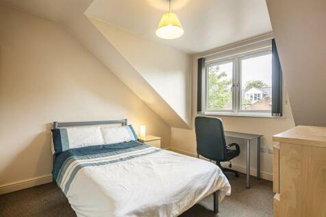 This cozy double bedroom features a comfortable...